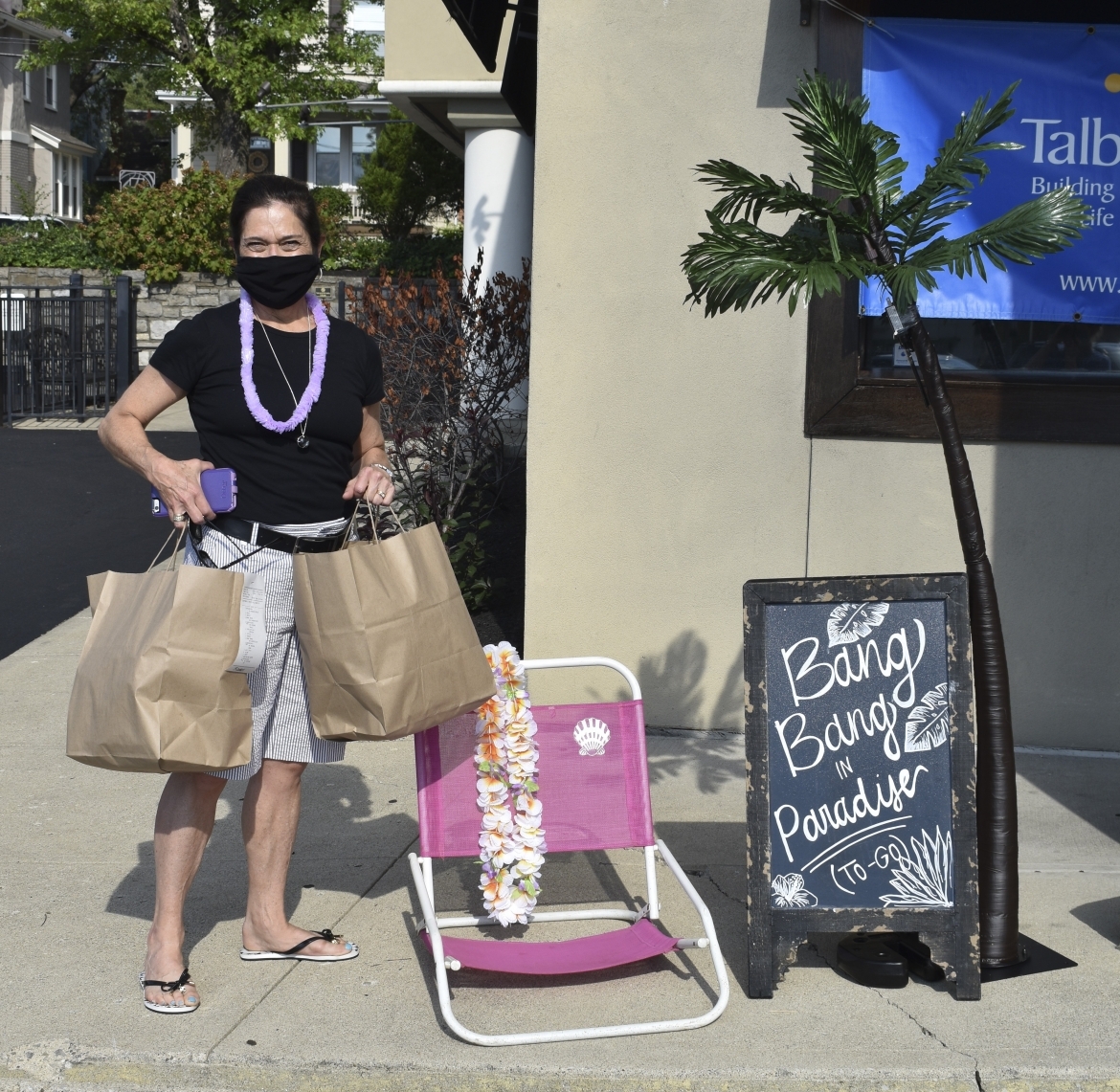 Woman with bags next to chair and sign